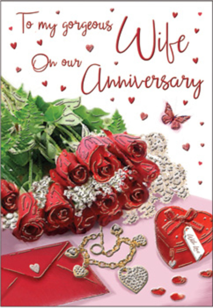 A rich and emotive anniversary scene unfolds in this image, crafted with the eye of an experienced Cranham florist who understands how to weave sentiment into every detail. The focal point is a generous bouquet of classic red roses, each bloom fully open and luxuriously full, their velvety petals layered in soft, rounded spirals of deep crimson. The roses are elegantly wrapped, their stems gathered and partially hidden, while lush green foliage curls around and between the flowers, amplifying their colour and giving the arrangement a sense of natural abundance. Around the bouquet, delicate heart motifs and fine, lace-like patterns adorn the card, their subtle textures catching the light like filigree. Scattered trinkets complete the story: a co-ordinating jewellery set glints in muted gold and silver tones, and a vivid red box sits nearby, its smooth surface and precise edges suggesting a cherished gift presented on many anniversaries past. The scripted message on the card flows in graceful, looping letters, surrounded by a soft scattering of tiny hearts that seem to float on the background. Warm, flattering lighting enhances the reds, greens, and touches of metallic shimmer, casting gentle shadows that lend depth without overpowering the scene. The combination of velvet petals, silky ribbon, polished metal, and fine paper textures creates a tactile sense of luxury and warmth. The overall atmosphere is one of deep romance and familiarity, as if this card had been chosen in Cranham after years of shared memories, ready to accompany a bouquet delivered locally to mark a milestone in a relationship that feels both secure and ever-new.